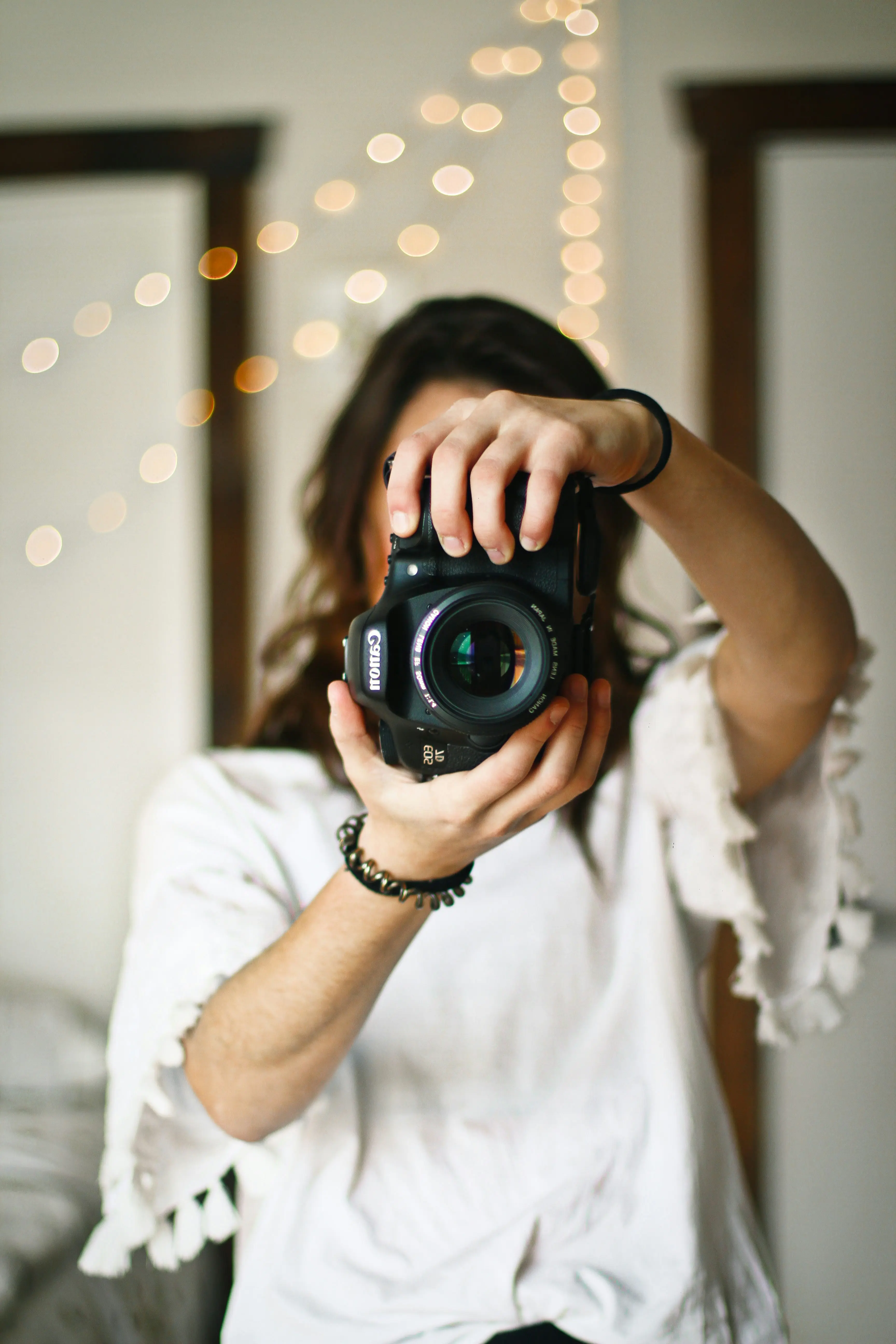 Woman holding camera in front of her face